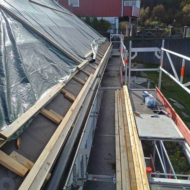 Arbeid på et hus med stillaser